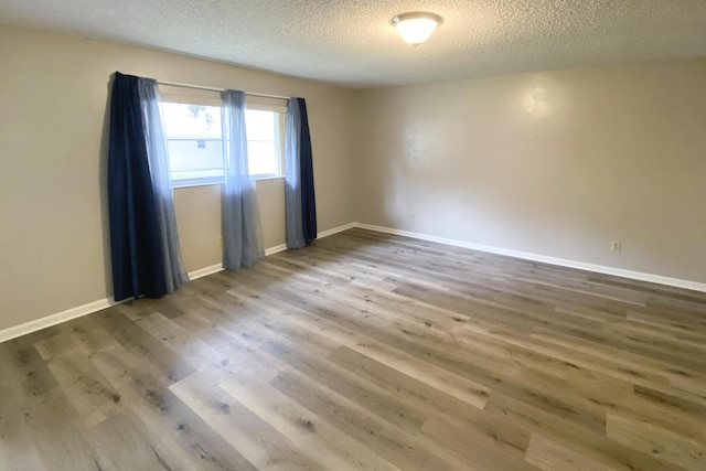 spare room with hardwood / wood-style flooring and a textured ceiling