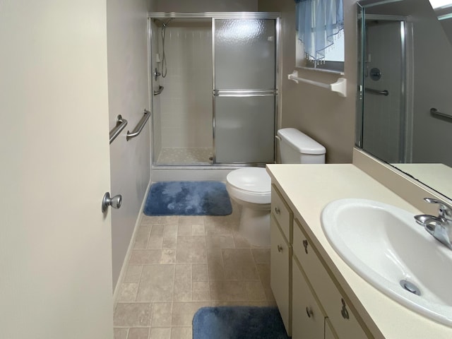 bathroom with vanity, a shower with door, and toilet