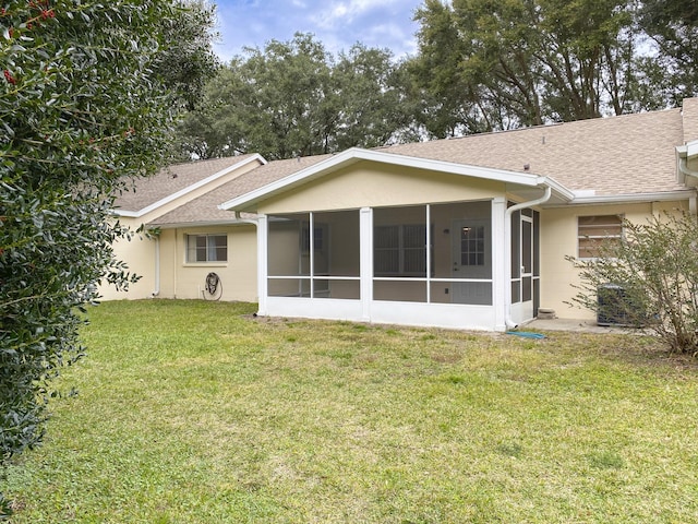 back of property with a yard and a sunroom