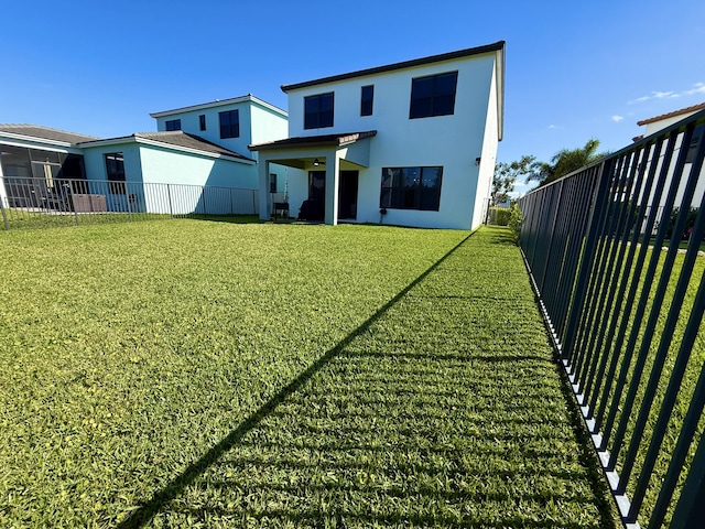 back of house featuring a lawn