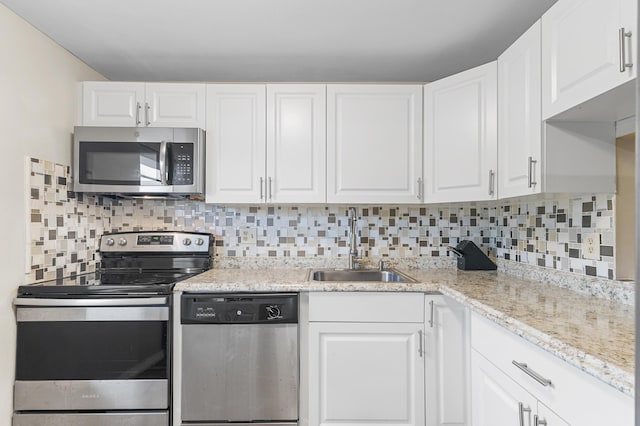 kitchen featuring tasteful backsplash, appliances with stainless steel finishes, sink, and white cabinets