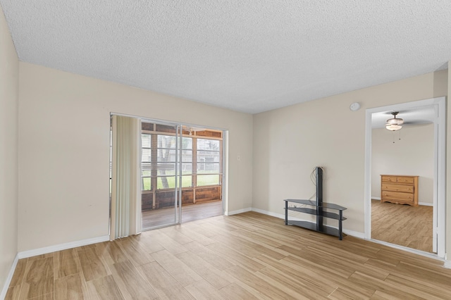 unfurnished room featuring light hardwood / wood-style flooring and a textured ceiling