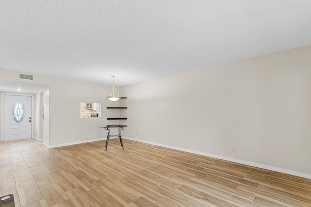 interior space featuring a textured ceiling and light wood-type flooring