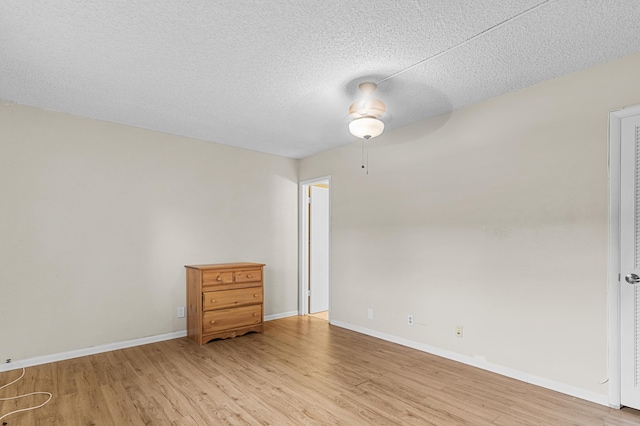 empty room with hardwood / wood-style flooring, ceiling fan, and a textured ceiling