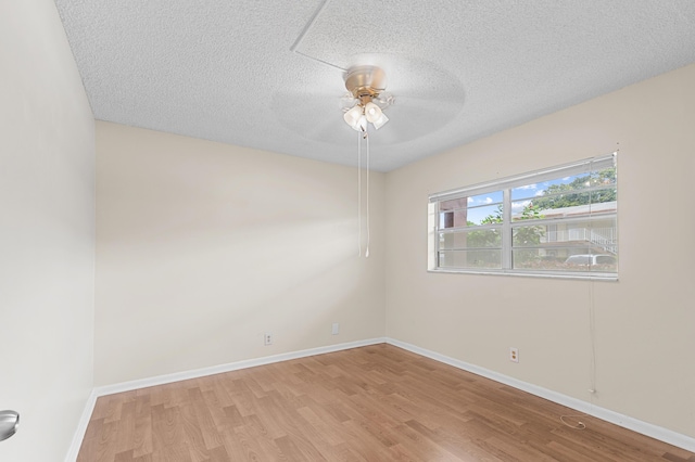 empty room featuring ceiling fan, a textured ceiling, and light hardwood / wood-style flooring