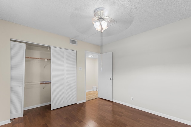 unfurnished bedroom featuring a textured ceiling, dark wood-type flooring, and ceiling fan