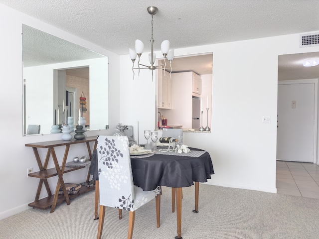 dining space featuring a notable chandelier, light colored carpet, and a textured ceiling