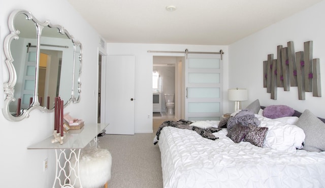 bedroom with connected bathroom, a barn door, and light carpet