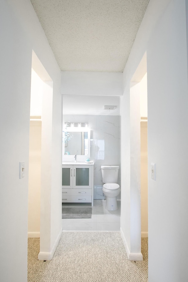 bathroom featuring vanity, toilet, and a textured ceiling