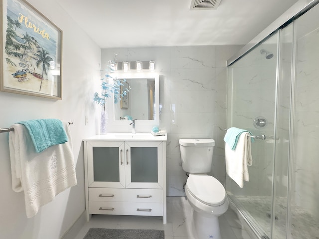 bathroom featuring vanity, toilet, and a shower with shower door