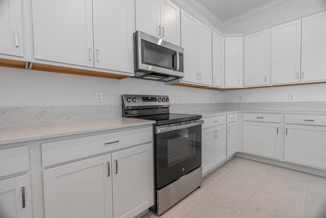 kitchen featuring light stone counters, sink, stainless steel appliances, and white cabinets