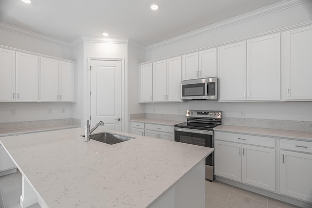 kitchen featuring appliances with stainless steel finishes, white cabinetry, sink, crown molding, and a center island with sink