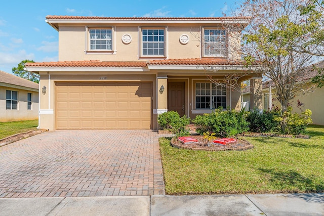 mediterranean / spanish-style house with stucco siding, decorative driveway, a front yard, an attached garage, and a tiled roof