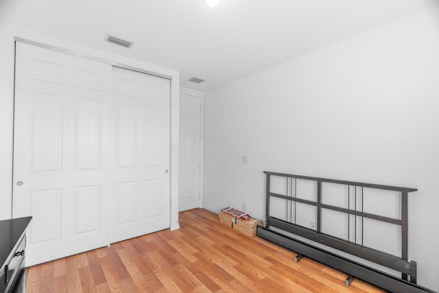 unfurnished bedroom featuring light hardwood / wood-style floors and a closet