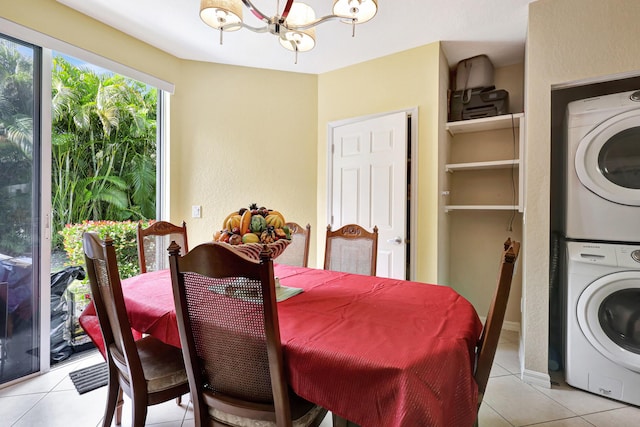 tiled dining area featuring a chandelier and stacked washer / dryer