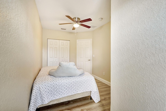 bedroom with hardwood / wood-style flooring, a closet, and ceiling fan