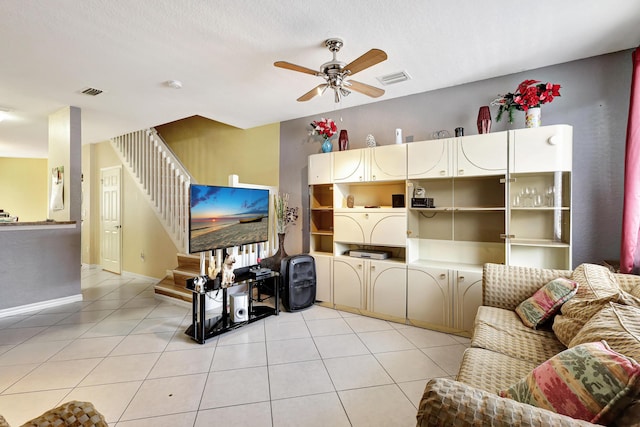 tiled living room featuring ceiling fan and a textured ceiling