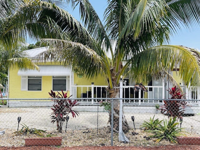 view of front of property with a fenced front yard, covered porch, and stucco siding