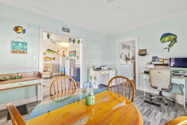 dining space featuring ornamental molding, a desk, a ceiling fan, and wood finished floors