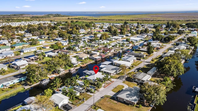 aerial view of property's location with a nearby body of water and nearby suburban area