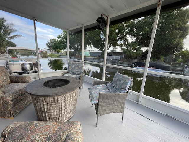 sunroom featuring a water view and an outdoor fire pit