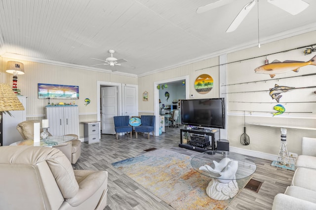 living room featuring ceiling fan, ornamental molding, and wood finished floors