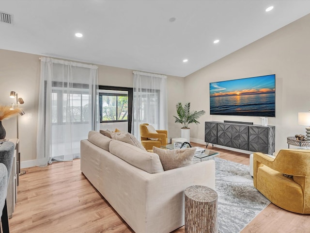 living room with lofted ceiling and light hardwood / wood-style flooring