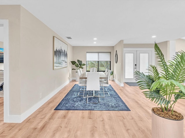 dining room with light hardwood / wood-style floors and french doors