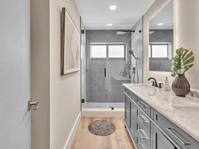 bathroom with hardwood / wood-style flooring, vanity, and a shower with door