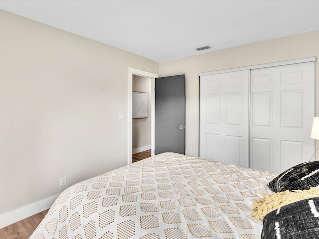 bedroom with wood-type flooring and a closet