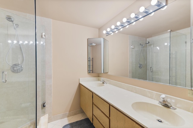 full bathroom featuring tile patterned flooring, a shower stall, double vanity, and a sink