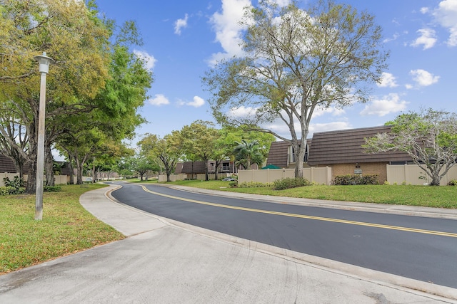 view of street with sidewalks, curbs, and street lighting