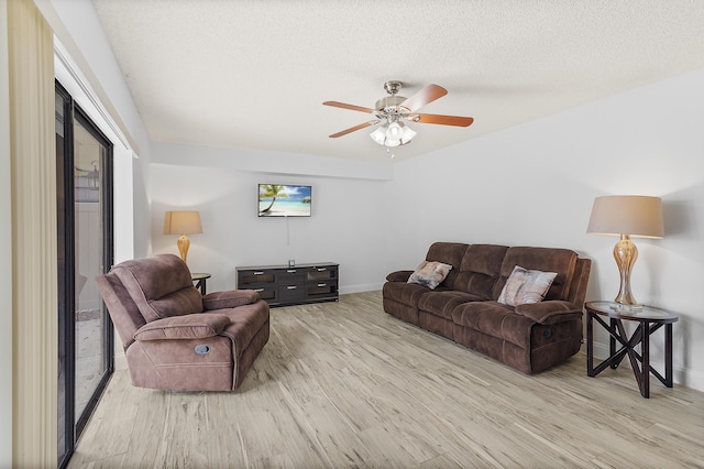 living area featuring ceiling fan, baseboards, a textured ceiling, and wood finished floors