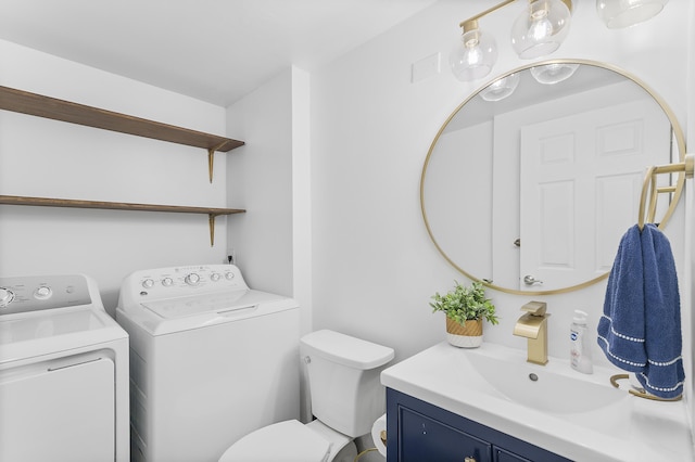 half bath with washing machine and clothes dryer, toilet, and vanity