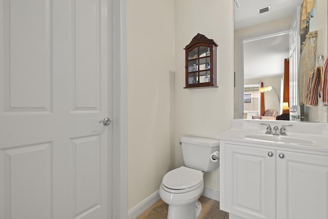 half bathroom with visible vents, toilet, vanity, tile patterned flooring, and baseboards