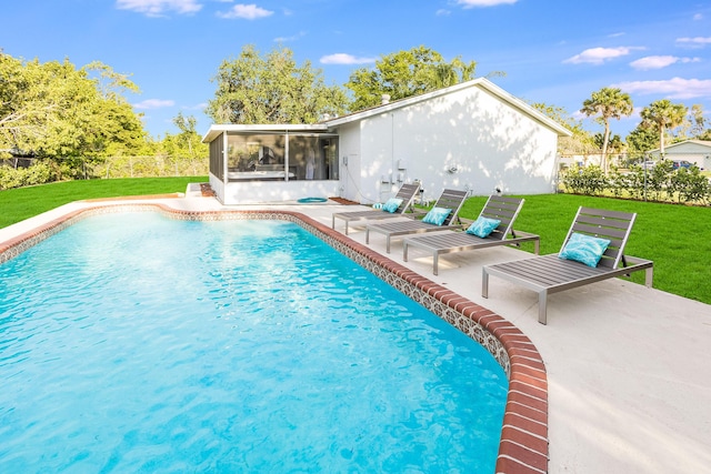 view of swimming pool with a lawn, a patio area, a sunroom, and a fenced in pool