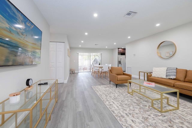 living area featuring baseboards, wood finished floors, visible vents, and recessed lighting