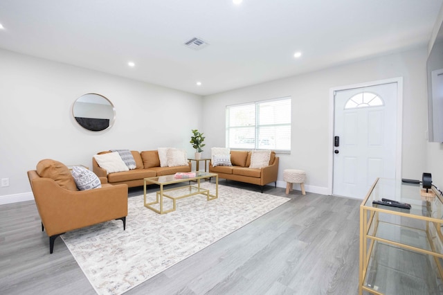 living room featuring baseboards, visible vents, wood finished floors, and recessed lighting