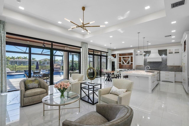 living room with a notable chandelier and sink