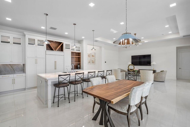 dining area with a raised ceiling and sink