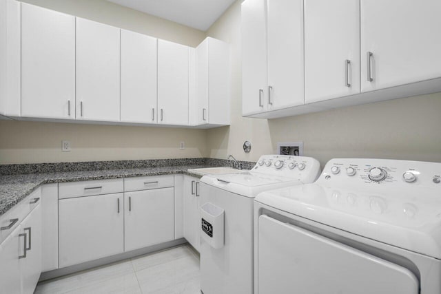 clothes washing area featuring cabinets, sink, light tile patterned floors, and independent washer and dryer