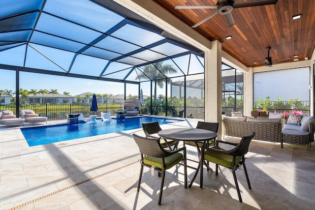 view of swimming pool with outdoor lounge area, glass enclosure, and a patio area