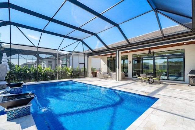 view of pool featuring a patio, pool water feature, ceiling fan, and a lanai