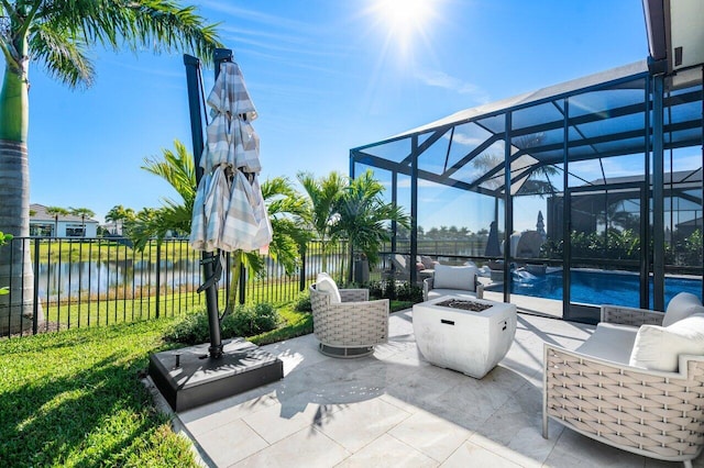 view of patio featuring a fire pit, a lanai, and a water view