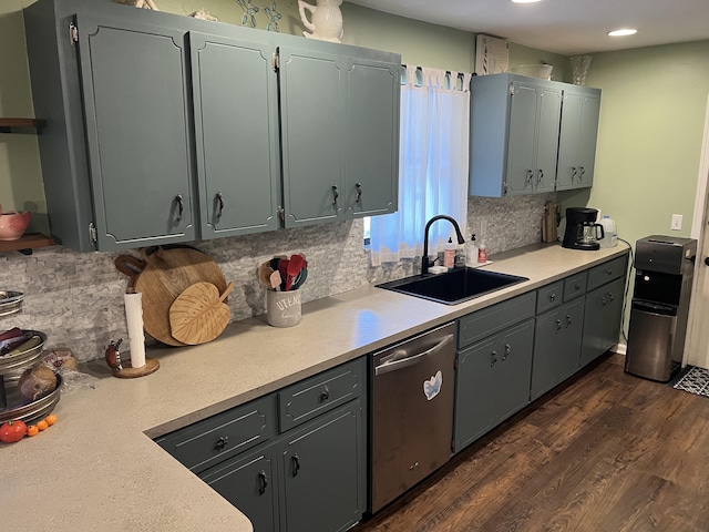 kitchen with dark wood-type flooring, stainless steel dishwasher, sink, and backsplash