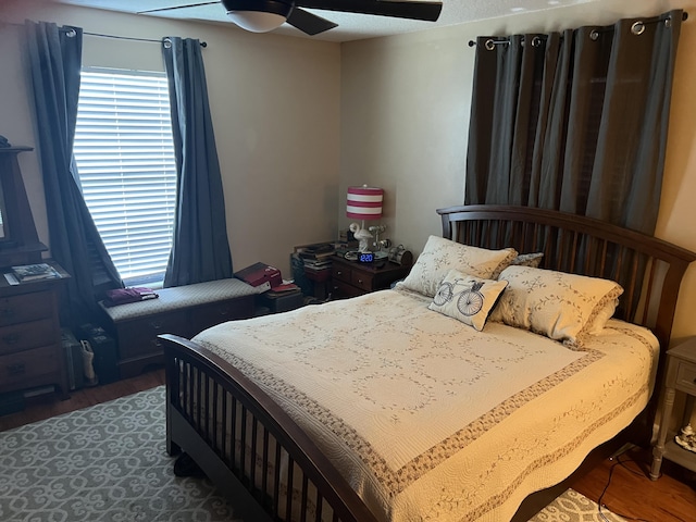 bedroom with dark hardwood / wood-style flooring and ceiling fan