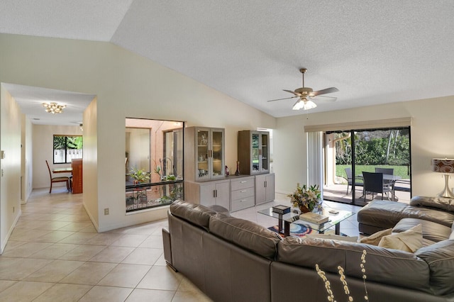 tiled living room with ceiling fan, lofted ceiling, and a textured ceiling