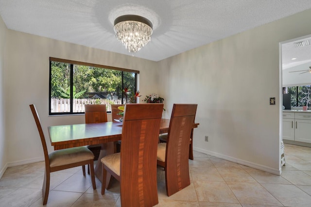 tiled dining area featuring an inviting chandelier and a textured ceiling