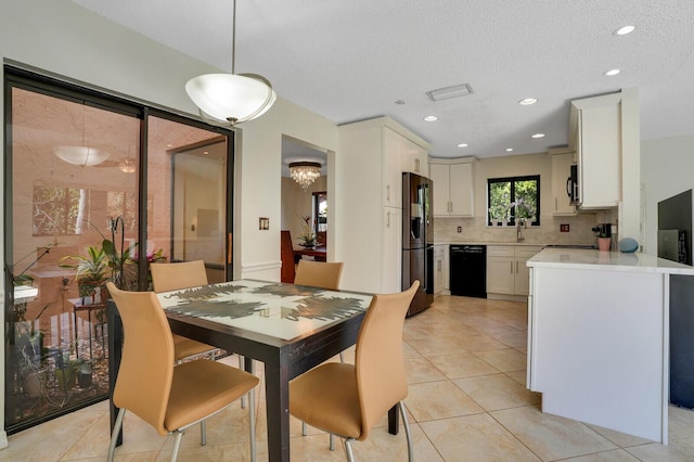 dining space featuring sink, a textured ceiling, and light tile patterned floors