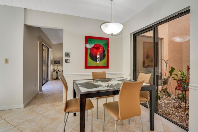 dining room featuring a textured ceiling and light tile patterned floors